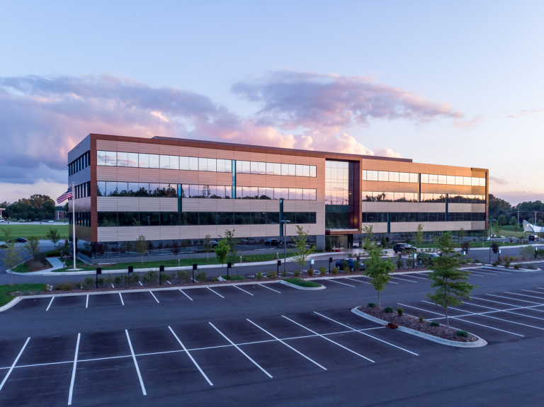 Modern office building with glass facade at sunset