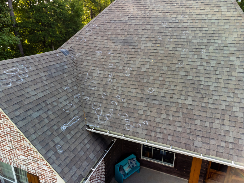 Aerial view of roof with chalk marks indicating possible hail damage.