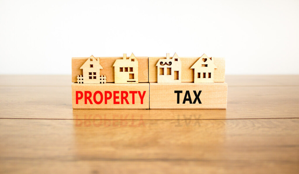 Wooden house models with 'Property Tax' text on wooden blocks.