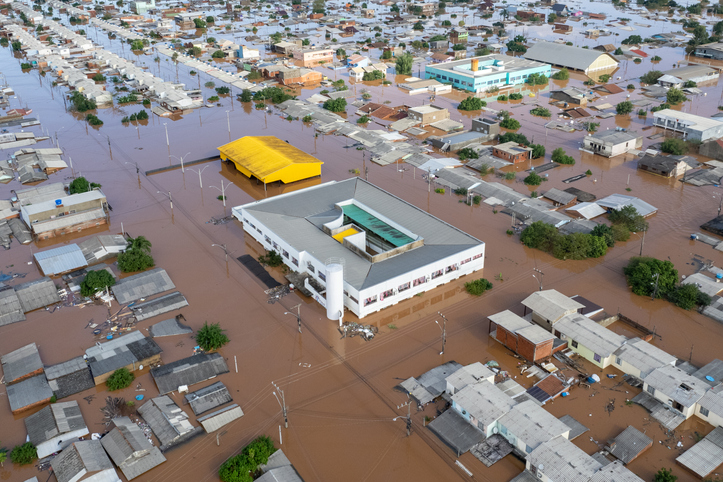 Aerial view of severe flooding in an urban area, impacting buildings and streets.