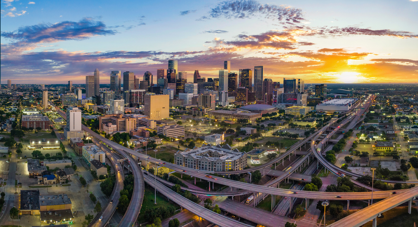 Stunning aerial view of Houston skyline at sunset with vibrant colors.