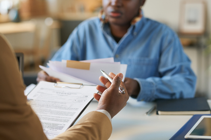 Business discussion with paperwork at an office table.