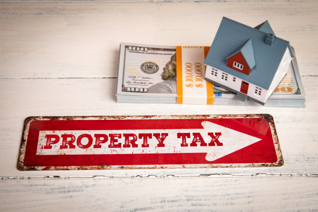 Property tax concept with house model and money stack.