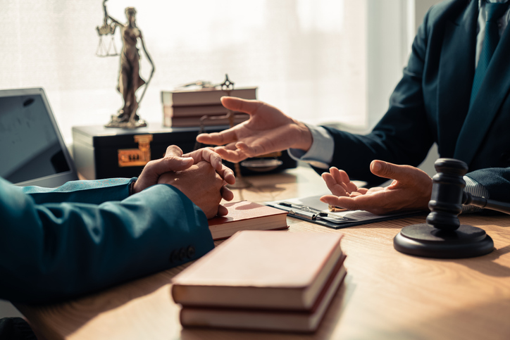 Two professionals discussing legal matters at an office desk.