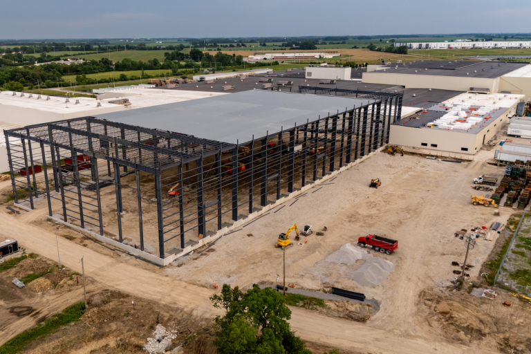 Aerial view of an industrial warehouse under construction with steel framework.