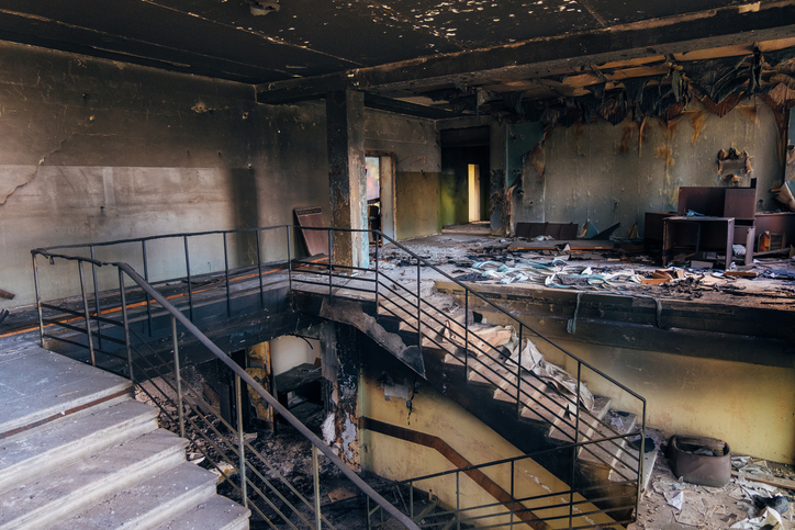 Abandoned building interior with damaged staircase and debris
