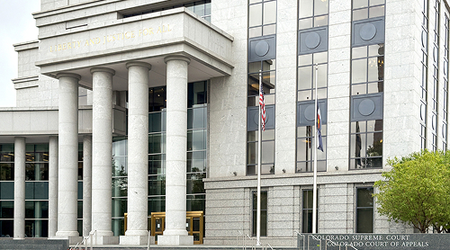 Colorado Supreme Court building with columns and flags.