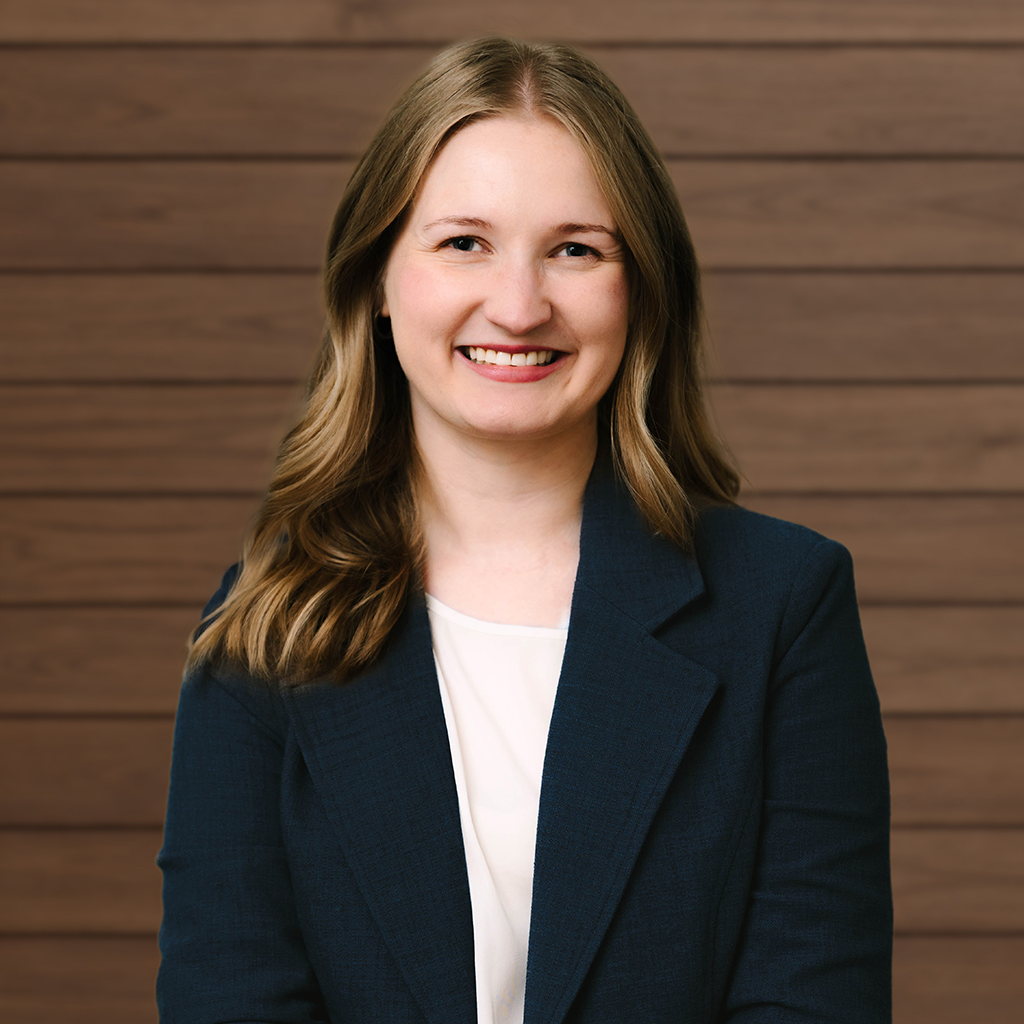 Smiling professional woman in blue blazer against wooden background